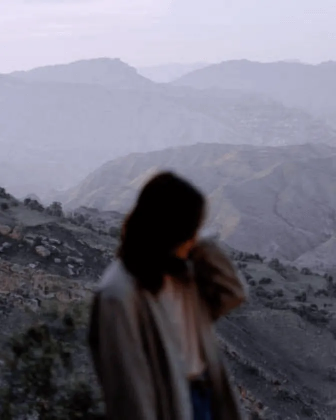 A girl standing on a mountain sideways